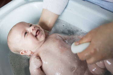 Mutter badet ihren kleinen Jungen in einer Wanne - LJF01360