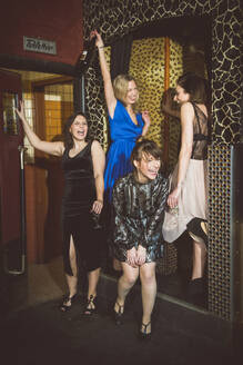 Vier glückliche Frauen beim geselligen Beisammensein in einem Club - HBIF00047