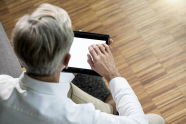 Senior man using tablet at home - SBOF02089