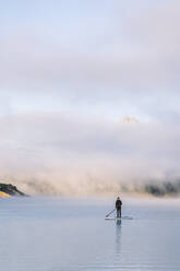 Frau Stand Up Paddle Surfing auf einem See - DGOF00462