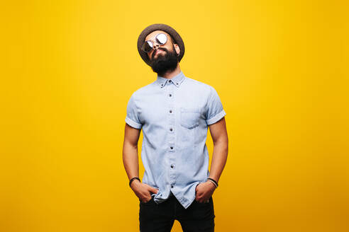 Portrait of a stylish young man in studio wearing sunglasses - DGOF00470