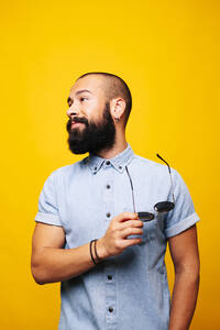 Portrait of a stylish young man in studio with sunglasses - DGOF00471