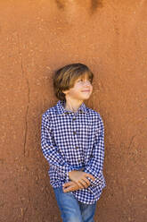 Portrait of Six year old boy against adobe wall - MINF13854