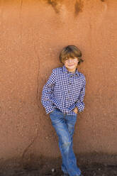 Porträt eines sechsjährigen Jungen vor einer Lehmziegelwand - MINF13855
