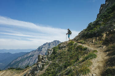 Männlicher Wanderer hält inne, um die Aussicht entlang des Pacific Crest Trail zu genießen, Goat Rocks Wilderness, Gifford Pinchot National Forest, Washington - MINF13891