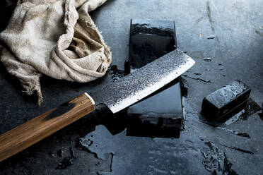 Nahaufnahme eines handgefertigten Messers auf einem Schleifstein. - MINF13998