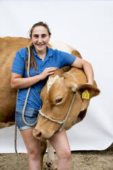 Portrait of smiling female farmer with a Guernsey cow. - MINF14001