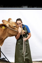 Porträt einer Bäuerin in grüner Schürze mit einer Guernsey-Kuh. - MINF14003