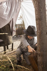 Six year old boy playing in an outdoor tent made of sheets - MINF14030