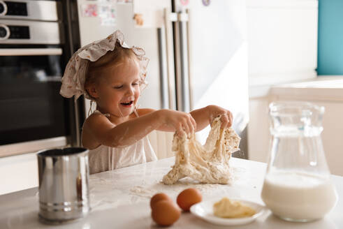 Kleines Mädchen beim Pizzabacken in der Küche - CAVF75498