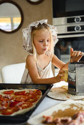 Little girl cooking pizza in the kitchen - CAVF75503