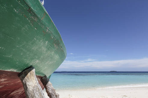 Boot am sonnigen Strand, Malediven, aufgestützt - HOXF05067