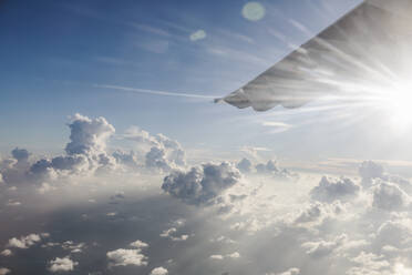Flugzeugflügel bewegt sich durch einen ruhigen, sonnigen, bewölkten Himmel - HOXF05068