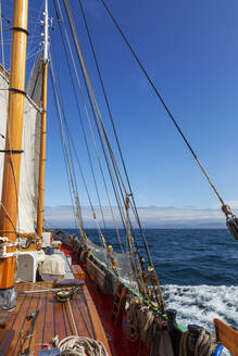 Hölzernes Segelboot auf sonnigem Meer - HOXF05133