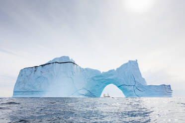 Majestätischer Eisbergbogen auf dem sonnigen blauen Atlantischen Ozean Grönlands - HOXF05159