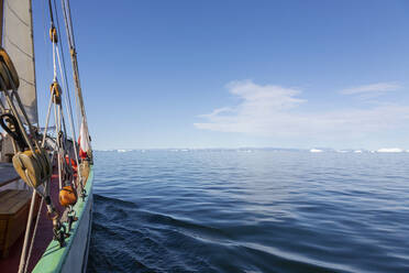 Schiff fährt auf Eisberge zu auf dem ruhigen sonnigen blauen Atlantischen Ozean Grönland - HOXF05169