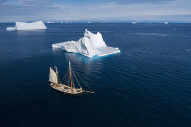 Schiff fährt an majestätischen Eisbergen auf dem sonnigen blauen Atlantik vorbei Grönland - HOXF05175