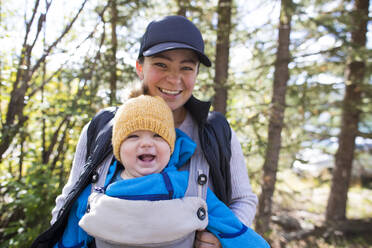 Portrait of mother and daughter smiling during walk through nature. - CAVF75505