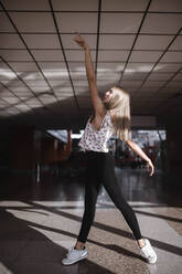 Young woman dancing in a waiting room - CAVF75519