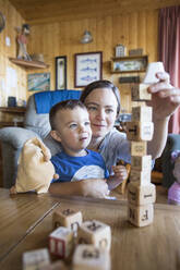 Mother helps son build block tower. - CAVF75529