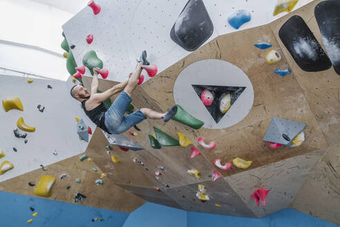 Man bouldering in climbing gym - AHSF01936