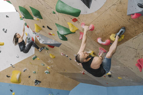 Man and woman bouldering in climbing gym - AHSF01939