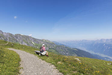 Schweiz, Kanton St. Gallen, Glarner Alpen, Mann macht Pause auf dem Panoramawanderweg in der Tektonikarena Sardona - GWF06475