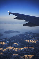 Frankreich, Auvergne-Rhone-Alpes, Flügel eines Airbus A321 im Flug über die europäischen Alpen und den Genfer See in der Morgendämmerung - RORF02016