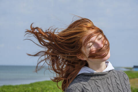 Vom Wind zerzaustes Haar eines Teenagers an der Küste, Skane, Schweden, lizenzfreies Stockfoto