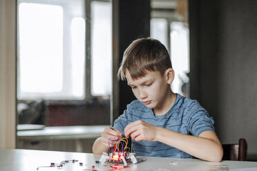 Boy assembling robot at home - EYAF00941