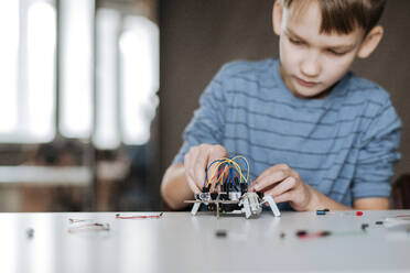 Junge baut zu Hause einen Roboter zusammen - EYAF00942