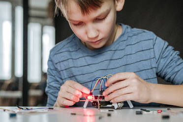 Boy assembling robot at home - EYAF00944