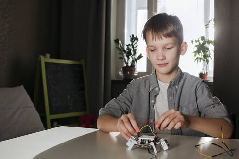 Junge baut zu Hause einen Roboter zusammen - EYAF00948