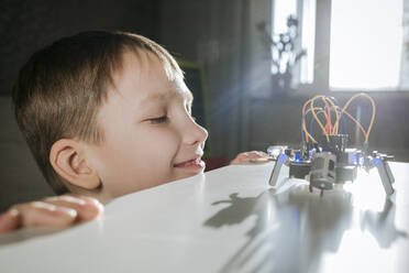 Junge baut zu Hause einen Roboter zusammen - EYAF00949