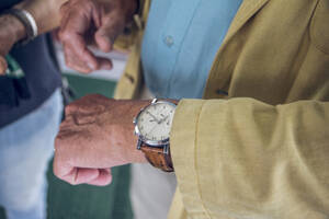 Nahaufnahme einer Armbanduhr, ein älterer Mann prüft die Zeit - MAMF01213