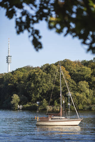 Germany, Brandenburg, Potsdam, Sailboat moored on Havel river with TV tower in background stock photo