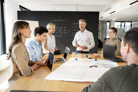 Geschäftsleute bei einem Workshop im Büro, die Pläne besprechen, lizenzfreies Stockfoto