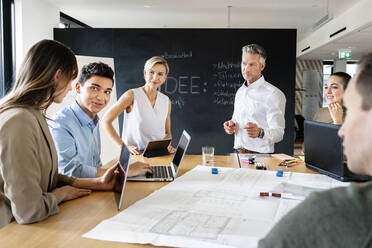 Geschäftsleute bei einem Workshop im Büro, die Pläne besprechen - PESF01922