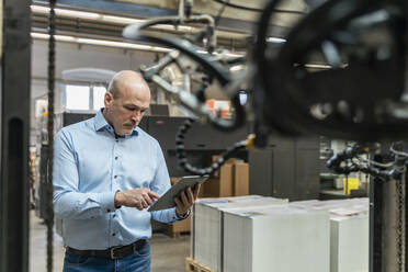 Businessman using tablet in a factory - DIGF09297