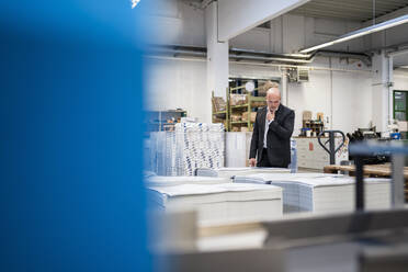 Businessman in a printing plant checking product - DIGF09316