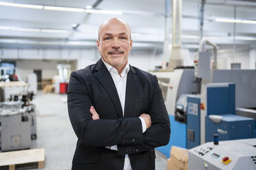 Portrait of a confident businessman in a factory - DIGF09317