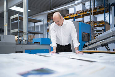 Businessman in a printing plant checking product - DIGF09324