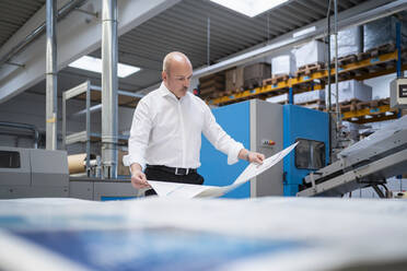 Businessman in a printing plant checking product - DIGF09327