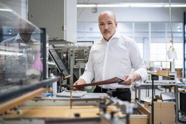 Businessman in a printing plant checking product - DIGF09340