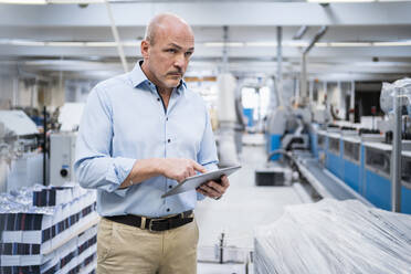 Businessman using tablet in a factory - DIGF09350