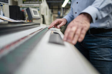 Hands of a man operating a machine in a factory - DIGF09380