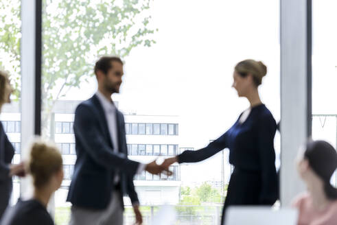 Businesswoman greeting colleagues in her team - BMOF00227