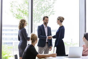 Businesswoman greeting colleagues in her team - BMOF00228