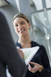 Young businesswoman talking to colleagues in a business meeting, portrait - BMOF00238