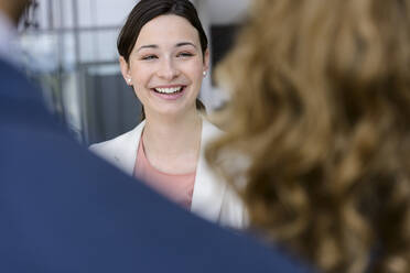 Young businesswoman talking to colleagues in a business meeting, portrait - BMOF00239
